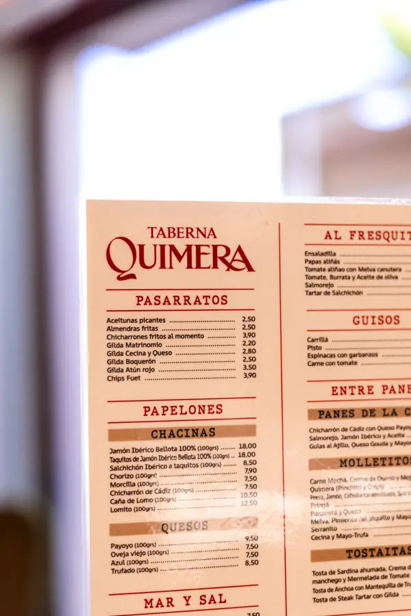 Carta de Taberna Quimera sobre una mesa de mármol