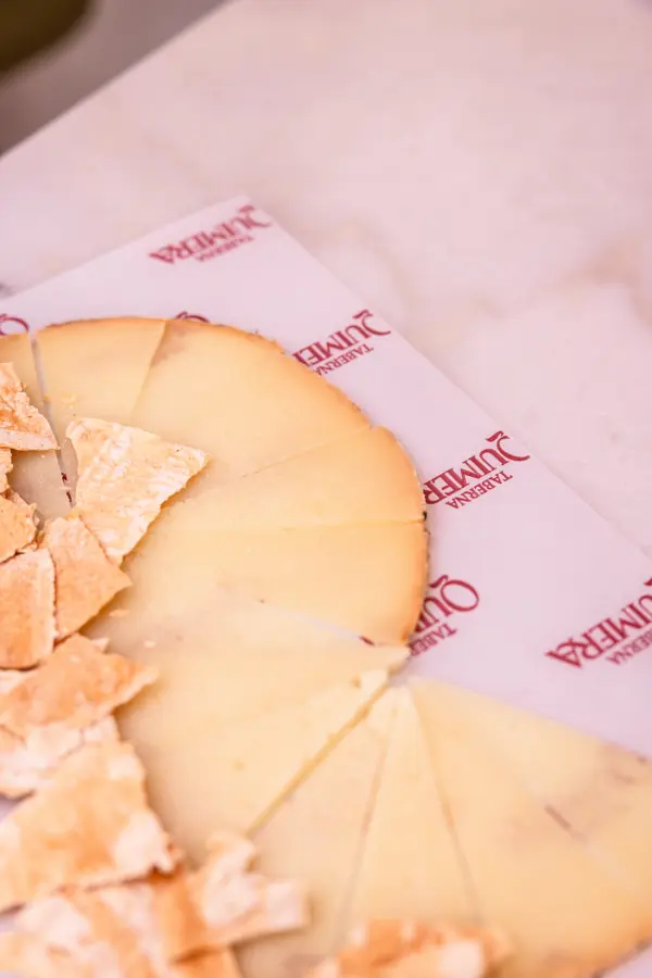 Cuñas de queso sobre papel de Taberna Quimera