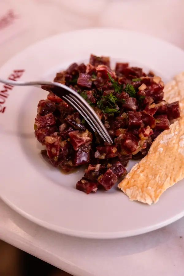 Steak tartar con tostas en un plato de Taberna Quimera